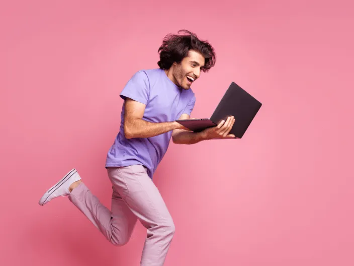 Hombre feliz corriendo con la computadora portátil
