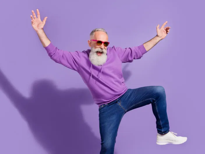 Hombre bailando feliz con jeans y gafas de sol
